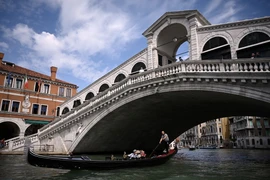 Khách du lịch đi thuyền gondola tại Venice, Italy. (Ảnh: AFP/TTXVN)