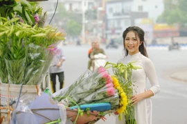 Hà Nội tháng vào tháng Tư, những nụ cười trong sáng không vướng phiền lo của những tà áo dài trắng học trò bên cạnh hoa loa kèn tinh khôi như níu chân du khách, tạo nên những khoảnh khắc đẹp đầy cảm xúc. (Ảnh: Thế Đại/Vietnam+)