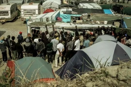 Người di cư xếp hàng nhận lương thực cứu trợ tại Calais, Pháp. (Nguồn: AFP/TTXVN)