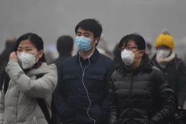 Người dân đeo khẩu trang để tránh không khí ô nhiễm tại Bắc Kinh, Trung Quốc. (Nguồn: THX/TTXVN)