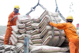 Bốc xếp ximăng từ tàu lên xe cho khách hàng. (Ảnh Viết Ý/TTXVN)