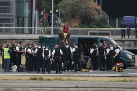 Lực lượng chức năng giải tán đám đông biểu tình tại sân bay London City. (Nguồn: AFP/TTXVN)
