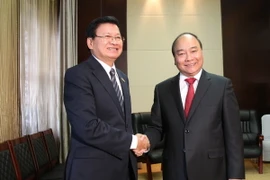 Thủ tướng Nguyễn Xuân Phúc gặp song phương Thủ tướng Lào Thongloun Sisoulith. (Ảnh: Phạm Kiên/TTXVN​)
