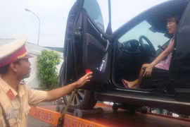 Chiếc xe ôtô và nữ tài xế cố thủ trong xe bị đưa về Trạm kiểm soát giao thông Ngã ba Thái Lan. (Ảnh: Sỹ Tuyên/TTXVN)