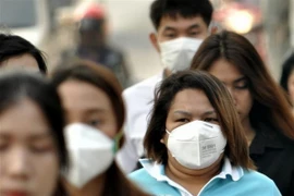 Người dân đeo khẩu trang để tránh tác hại của ô nhiễm không khí tại Bangkok, Thái Lan. (Nguồn: THX/TTXVN)