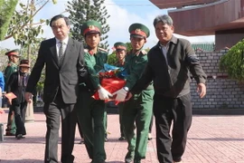 Các đại biểu đưa hài cốt các liệt sỹ về nơi an nghỉ cuối cùng tại Nghĩa trang Liệt sỹ thị xã An Khê. (Ảnh: Dư Toán/TTXVN)