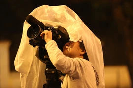 Che mưa cho thiết bị và đã sẵn sàng để có những khuôn hình đầu tiên. (Ảnh: Minh Sơn/Vietnam+)