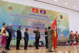 Thượng tướng Vilay Lakhamphong, Bộ trưởng Bộ Công an Lào gắn Huân chương Itsala Hạng II của Đảng Nhà nước Lào cho Cơ quan Đại diện Bộ Công Việt Nam tại Lào. (Ảnh: Phạm Kiên/TTXVN)