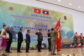 Thượng tướng Vilay Lakhamphong, Bộ trưởng Bộ Công an Lào gắn Huân chương Itsala Hạng II của Đảng Nhà nước Lào cho Cơ quan Đại diện Bộ Công Việt Nam tại Lào. (Ảnh: Phạm Kiên/TTXVN)
