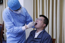 Nhân viên y tế lẫy mẫu xét nghiệm virus SARS-CoV-2 cho các phóng viên, biên tập, kỹ thuật viên các cơ quan thông tấn, báo chí. (Ảnh: Dương Giang/TTXVN)