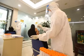 Nhân viên y tế lấy mẫu xét nghiệm. (Ảnh: Minh Quyết/TTXVN)