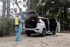 Khử khuẩn xe do tài xế M.T.T chở khách về Sóc Trăng. (Ảnh: TTXVN phát)
