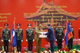 Thay mặt lãnh đạo Đảng, Nhà nước, Đại tướng Tô Lâm trao tặng Huân chương của Nhà nước CHXHCN Việt Nam cho các tập thể, các nhân thuộc lực lượng Công an nhân dân Lào. (Ảnh: Phạm Kiên/TTXVN)