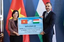 Phó Quốc vụ khanh Bộ Ngoại giao và Kinh tế Đối ngoại István Joó trao tặng cho Đại sứ Việt Nam Nguyễn Thị Bích Thảo. (Ảnh: TTXVN phát)