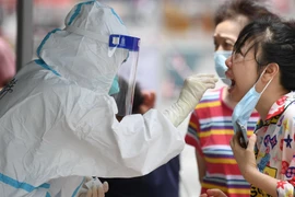 Nhân viên y tế lấy mẫu xét nghiệm COVID-19 cho người dân tại Quảng Châu, tỉnh Quảng Đông, Trung Quốc. (Ảnh: THX/TTXVN)