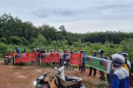 Người dân căng băngrôn, phát loa để đòi tiền đã mua đất trước đó tại dự án An Điền. (Ảnh: TTXVN)