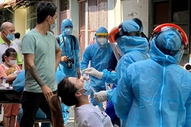 Tiến hành lấy mẫu xét nghiệm virus COVID-19 cho người dân. (Ảnh: Hồng Giang/TTXVN)