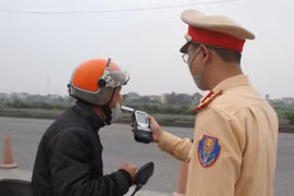 Cảnh sát giao thông kiểm tra nồng độ cồn của người điều khiển phương tiện. (Ảnh: Thùy Dung/TTXVN)