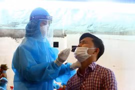 Cán bộ y tế lấy mẫu xét nghiệm cho người dân phường Hà Huy Tập, thành phố Vinh, tỉnh Nghệ An. (Ảnh: Tá Chuyên/TTXVN)