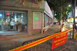 Lực lượng chức năng lập chốt chặn, phong tỏa quán cà phê Aha ở 189 Bà Triệu. (Ảnh: Minh Đức/TTXVN)