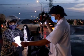 Kiểm tra giấy tờ xe chủ phương tiện tại chốt kiểm soát dịch bệnh COVID -19 ở Vĩnh Phúc. (Ảnh: Hoàng Hùng/TTXVN)