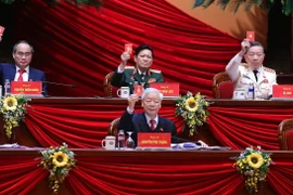 Tổng Bí thư, Chủ tịch nước Nguyễn Phú Trọng và các thành viên Đoàn Chủ tịch biểu quyết thông qua danh sách Ban Thẩm tra tư cách đại biểu. (Ảnh: TTXVN)