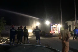 Lực lượng chức năng triển khai các biện pháp dập tắt đám cháy. (Ảnh: Đậu Tất Thành/TTXVN)