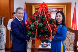 Đồng chí Thongsavane Phomvihane, Ủy viên Tung ương Đảng, Thứ trưởng Bộ Ngoại giao Lào tặng lẵng hoa chúc mừng Đại biện lâm thời Đại sứ quán Việt Nam tại Lào Trịnh Thị Tâm. (Ảnh: Phạm Kiên/TTXVN)