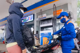 Mua bán xăng dầu tại một điểm kinh doanh của Petrolimex. (Ảnh: Trần Việt/TTXVN)