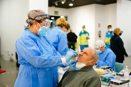 Nhân viên y tế lẫy mẫu xét nghiệm COVID-19 tại Madrid, Tây Ban Nha, ngày 29/9/2020. (Ảnh: AFP/TTXVN)