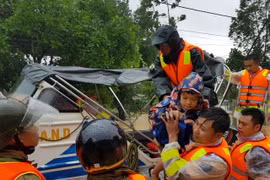 Di chuyển người dân ra khỏi khu vực ngập lũ tại huyện Cam Lộ. (Ảnh: Thanh Thủy/TTXVN)