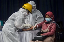 Nhân viên y tế lấy mẫu xét nghiệm COVID-19 cho người dân tại tỉnh Tây Java, Indonesia ngày 4/4/2020. (Ảnh: THX/TTXVN)