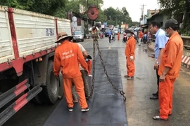 Lực lượng thi công gia cố các tấm thép trên mặt cầu An Viễn. (Ảnh: TTXVN phát)