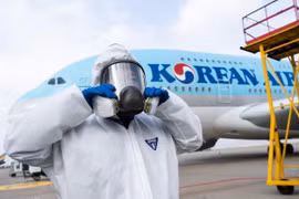 Nhân viên chuẩn bị phun thuốc khử trùng trên máy bay của Korean Air nhằm ngăn chặn sự lây lan của dịch COVID-19. (Ảnh: AFP/TTXVN)