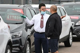 Nhân viên giới thiệu khách tới mua xe tại London, Anh. (Nguồn: AFP)