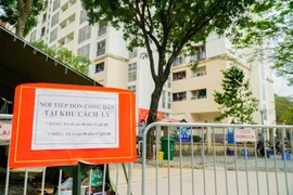 Đồ trước khi gửi vào trong khu cách ly được các lực lượng chức năng đóng gói, ghi tên, phun khử khuẩn cẩn thận. (Ảnh: Minh Hiếu/Vietnam+) 