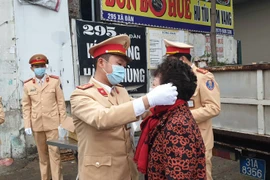 Nhiều khẩu trang đã được phát miễn phí tới tay người tham gia giao thông. (Ảnh: PV/Vietnam+) 