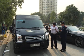 Thanh tra giao thông vận tải Hà Nội kiểm tra xe Limousine chạy quanh cổng sau khu vực Big C. (Ảnh: Đức Hùng/Vietnam+)