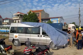 Hiện trường vụ tai nạn giao thông giữa xe chở khách bị tàu hỏa đâm tại Nam Định. (Ảnh: Văn Đạt/TTXVN)