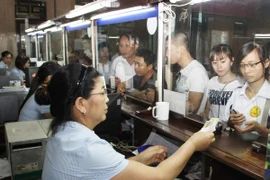 Hành khách mua vé tàu ở ga Hà Nội. (Ảnh: Thế Duyệt/TTXVN)