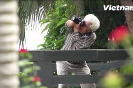 Suốt bốn thập kỷ qua, người thương binh Bùi Đăng Thanh vẫn miệt mài cầm máy một tay, cần mẫn ghi lại từng vẻ đẹp trong cuộc sống. (Ảnh: Tùng Lâm/Vietnam+)