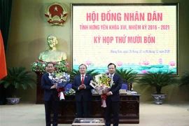Bí thư Tỉnh ủy Hưng Yên Đỗ Tiến Sỹ tặng hoa chúc mừng ông Nguyễn Hùng Nam (bên trái) giữ chức Phó Chủ tịch Ủy ban Nhân dân tỉnh Hưng Yên nhiệm kỳ 2016-2021. (Ảnh: Đinh Tuấn/TTXVN)
