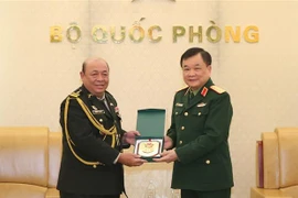 Thượng tướng Hoàng Xuân Chiến trao biểu tượng Bộ Quốc phòng Việt Nam tặng Đại tá Rem Kan, Tùy viên Quân sự Campuchia tại Việt Nam. (Ảnh: Hồng Pha/TTXVN phát)