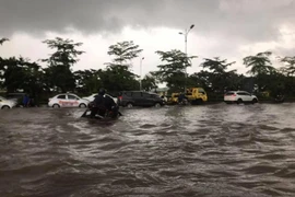 Việc ngập sâu khiến cho nhiều phương tiện đi lại rất khó khăn. (Ảnh: PV/Vietnam+)