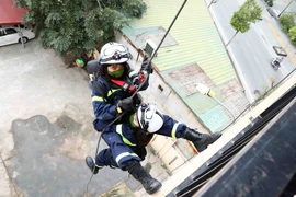 Hình ảnh nữ cảnh sát đu mình trên dây luyện tập công tác cứu nạn