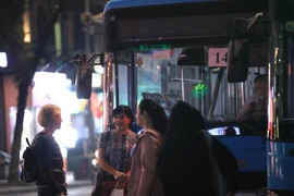 Một nhóm du khách không đeo khẩu trang tại khu vực Hồ Gươm tối 16/1. (Ảnh: Hoàng Hiếu/TTXVN)