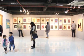 Có rất nhiều người yêu nghệ thuật đi cùng gia đình đến để xem tranh. (Ảnh: PV/Vietnam+)