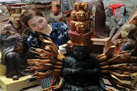 Nghệ nhân làng nghề Sơn Đồng hoàn thiện sản phẩm chuẩn bị hàng cho dịp Tết. (Ảnh: TTXVN phát)