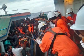Đưa các công dân Sri Lanka từ tàu cá Lady R3 lên tàu Helios Leader. (Ảnh: TTXVN phát)