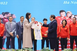 Thủ tướng Phạm Minh Chính tặng Thủ tướng New Zealand Jacinda Ardern chiếc áo thi đấu có chữ ký của đội tuyển bóng đá nữ Việt Nam. (Ảnh: Dương Giang/TTXVN)